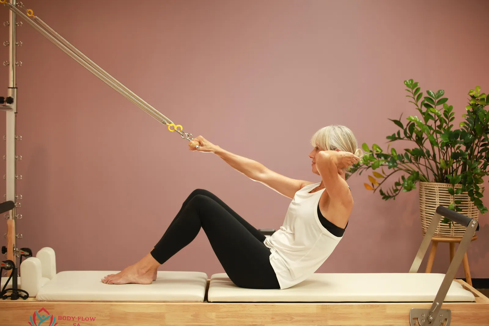 Nadine demonstrating seated strap work on the reformer